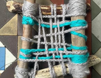 Sticks with blue and grey string forming a net