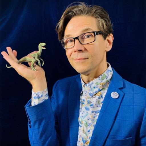 A person wearing a bright blue suit is holding a tiny dinosaur